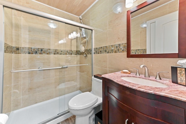 full bathroom with toilet, vanity, tile walls, backsplash, and a stall shower