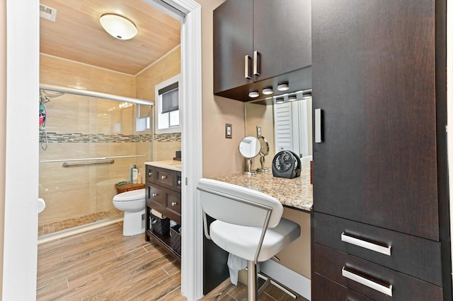 full bathroom featuring toilet, visible vents, vanity, a shower stall, and wood tiled floor