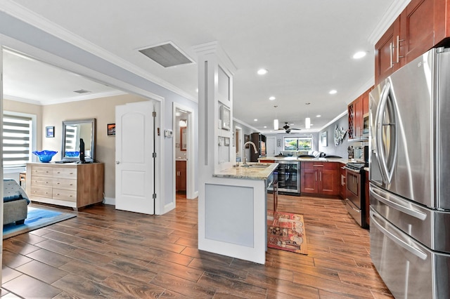 kitchen featuring visible vents, wine cooler, a peninsula, stainless steel appliances, and a sink