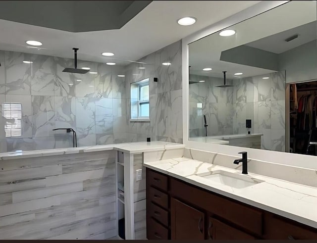 full bathroom with a marble finish shower, vanity, and recessed lighting