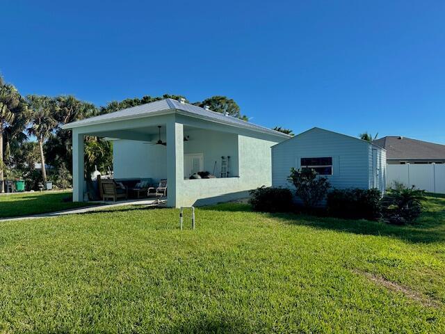 back of property featuring a yard, a patio area, ceiling fan, and stucco siding