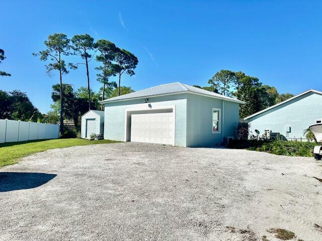 garage featuring driveway and fence