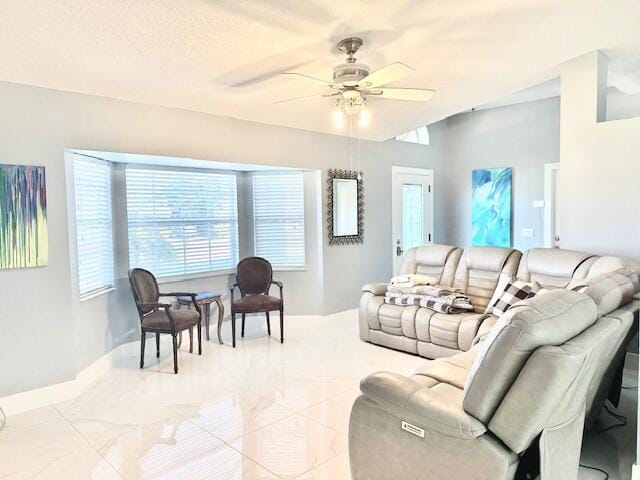 living area with a textured ceiling and a ceiling fan