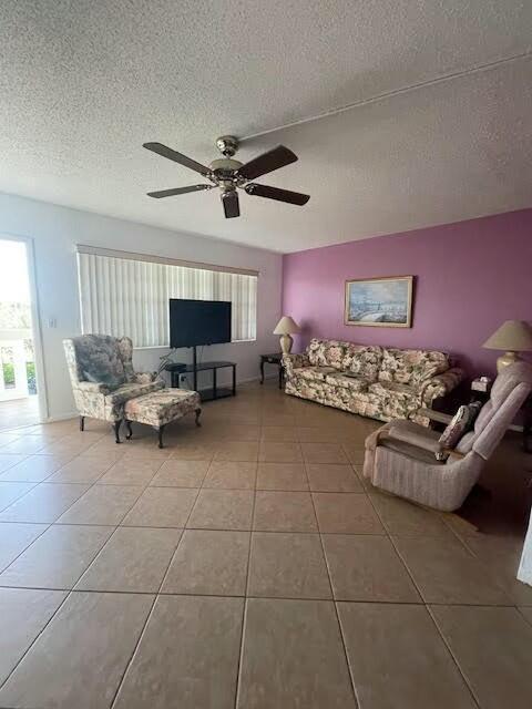 unfurnished living room with tile patterned floors, a textured ceiling, and ceiling fan