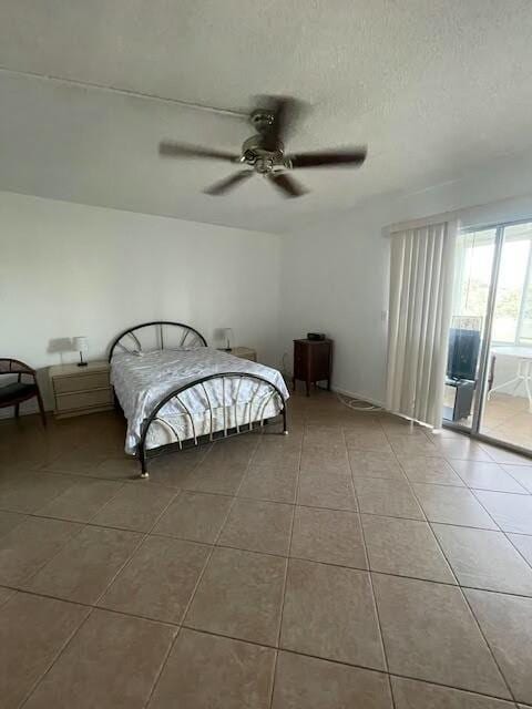 unfurnished bedroom featuring tile patterned floors, a textured ceiling, access to exterior, and a ceiling fan