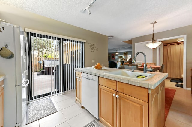 kitchen featuring tile counters, light tile patterned flooring, a sink, a textured ceiling, and white appliances