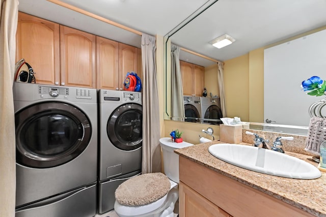 washroom featuring cabinet space, washer and dryer, and a sink