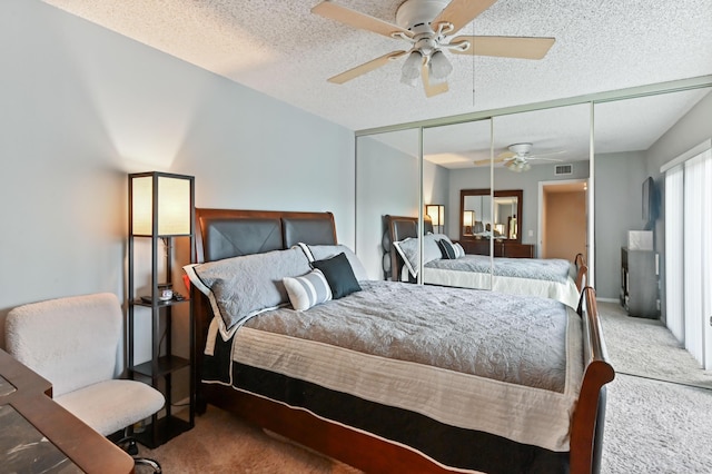 bedroom featuring visible vents, a ceiling fan, a textured ceiling, carpet flooring, and a closet