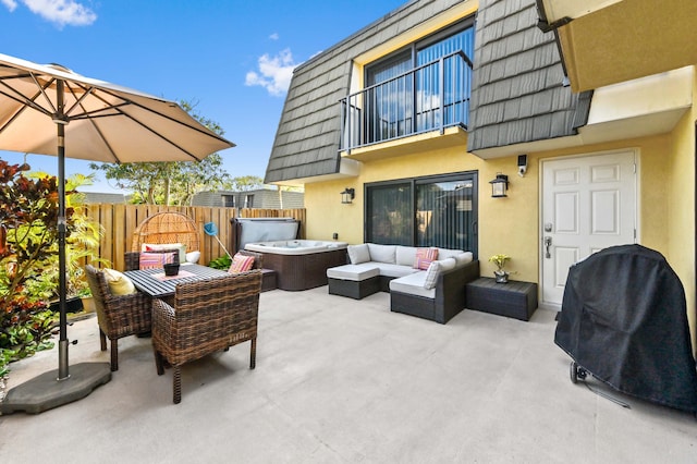 view of patio with a balcony, fence, an outdoor living space, grilling area, and a hot tub