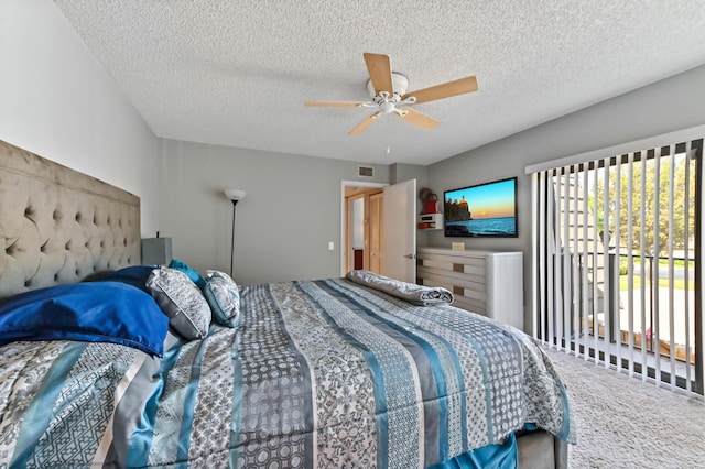 carpeted bedroom with ceiling fan, a textured ceiling, and visible vents