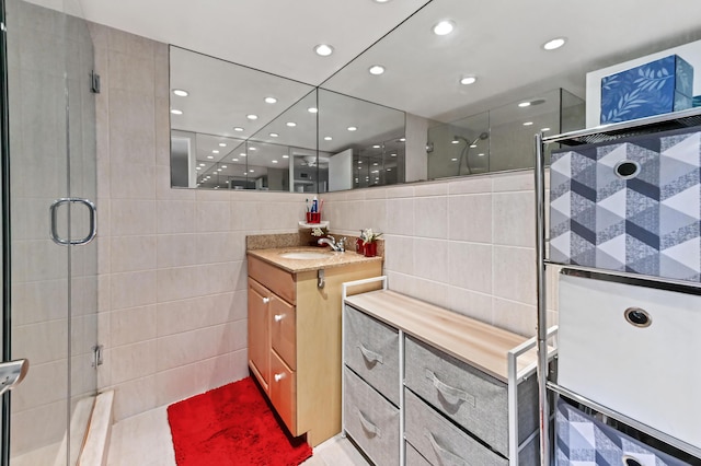 full bathroom featuring vanity, a shower stall, tile walls, and recessed lighting