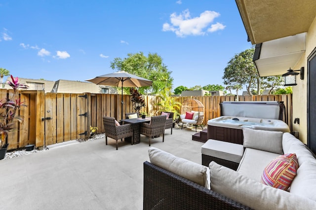 view of patio with a hot tub, a fenced backyard, and outdoor lounge area