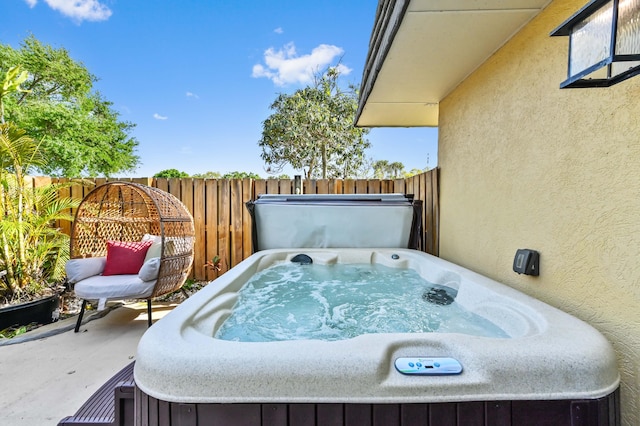 view of patio with fence and a hot tub