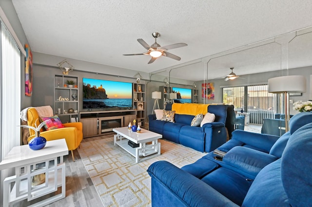 living room featuring a textured ceiling, ceiling fan, and wood finished floors