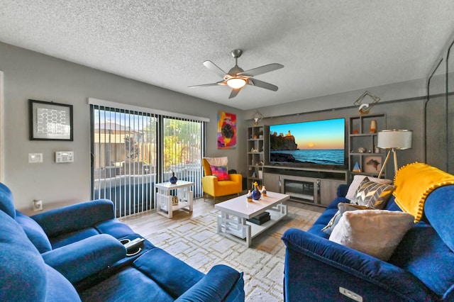 living room with a ceiling fan, a textured ceiling, and wood finished floors