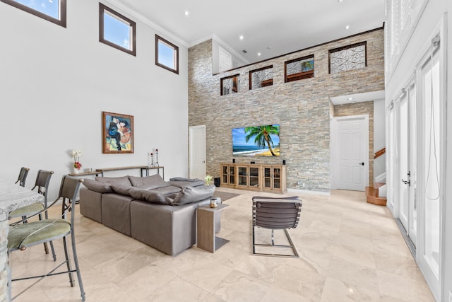 living area featuring crown molding, a high ceiling, and stairs