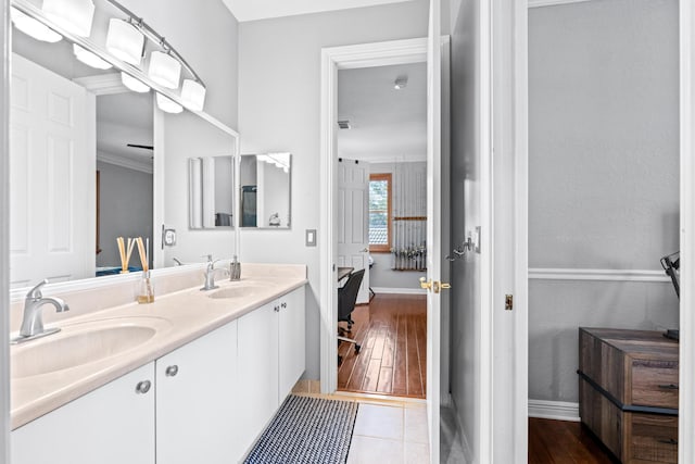 full bath with double vanity, tile patterned flooring, baseboards, and a sink