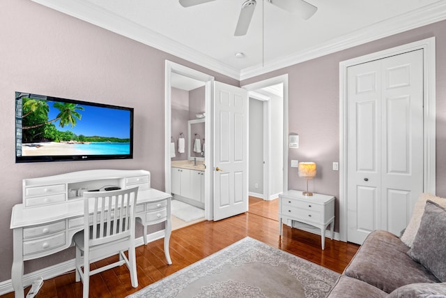 home office featuring ceiling fan, baseboards, light wood-style flooring, and crown molding