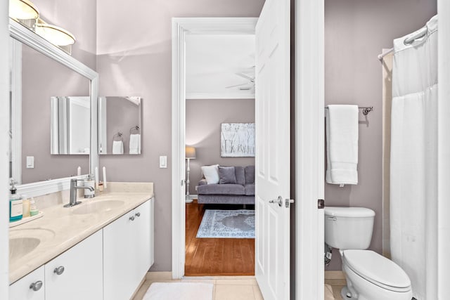 full bathroom with double vanity, toilet, ensuite bath, crown molding, and a sink