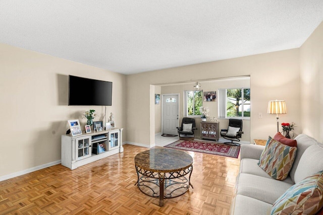 living area featuring baseboards and a textured ceiling