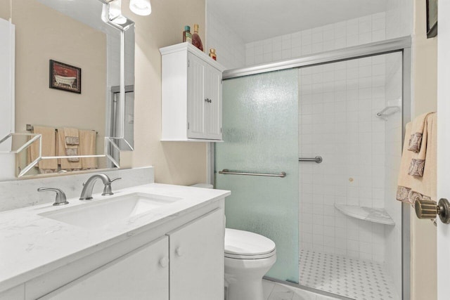 bathroom featuring a tile shower, vanity, and toilet