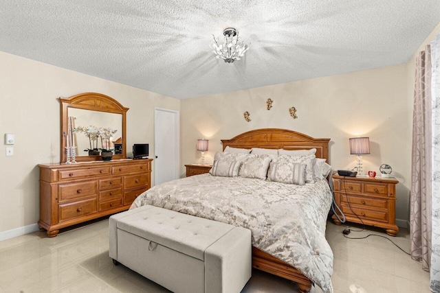 bedroom with a textured ceiling, a notable chandelier, and baseboards