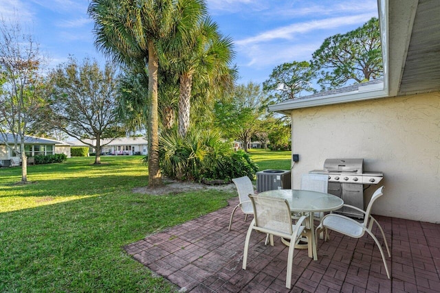 view of patio featuring central AC, outdoor dining area, and grilling area