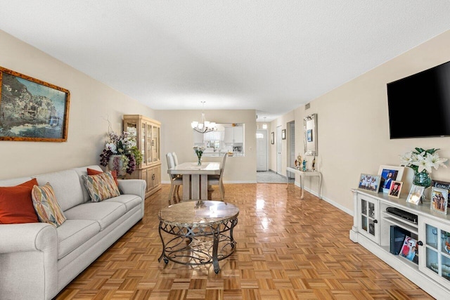 living room with a textured ceiling, baseboards, and an inviting chandelier