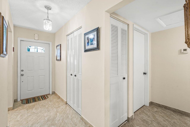 foyer entrance with a textured ceiling and baseboards