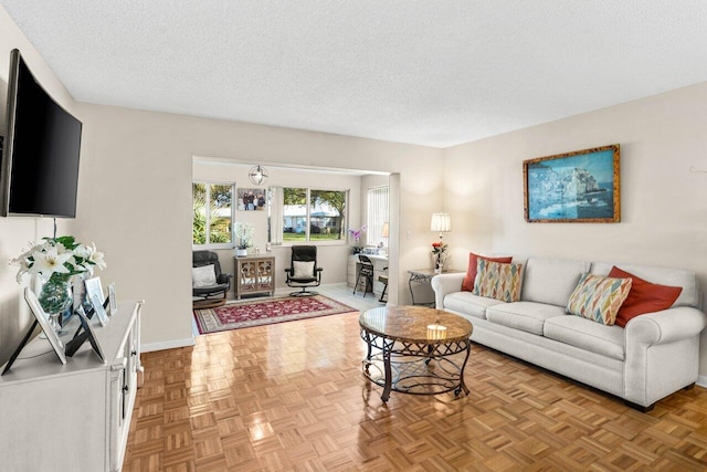 living area with a textured ceiling and baseboards