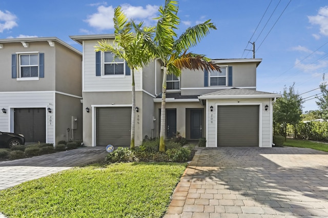 multi unit property with a garage, decorative driveway, and stucco siding