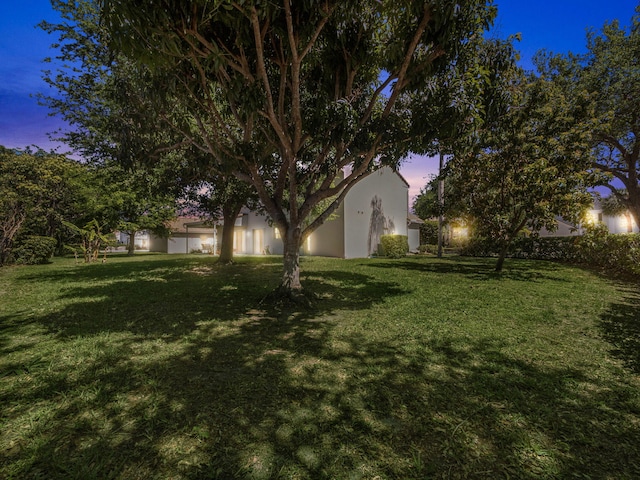 10282 Hunt Club Ln, Palm Beach Gardens, FL 33418 - yard at dusk featuring a lawn