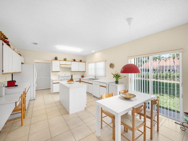 10282 Hunt Club Ln, Palm Beach Gardens, FL 33418 - kitchen with under cabinet range hood, a kitchen island, white appliances, a sink, and light countertops