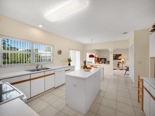10282 Hunt Club Ln, Palm Beach Gardens, FL 33418 - kitchen featuring white dishwasher, a textured ceiling, a sink, a kitchen island, and light countertops