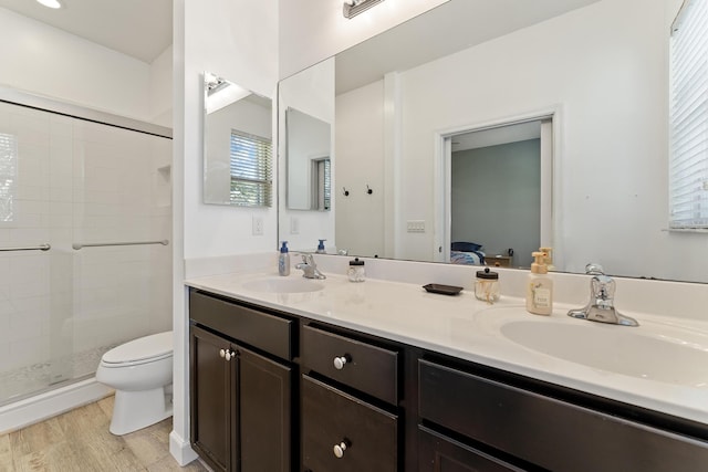 full bathroom featuring a sink, toilet, wood finished floors, and a shower stall