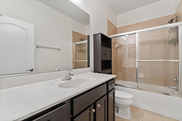 full bathroom featuring vanity, tile patterned floors, toilet, and bath / shower combo with glass door