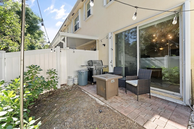 view of patio with fence and a grill