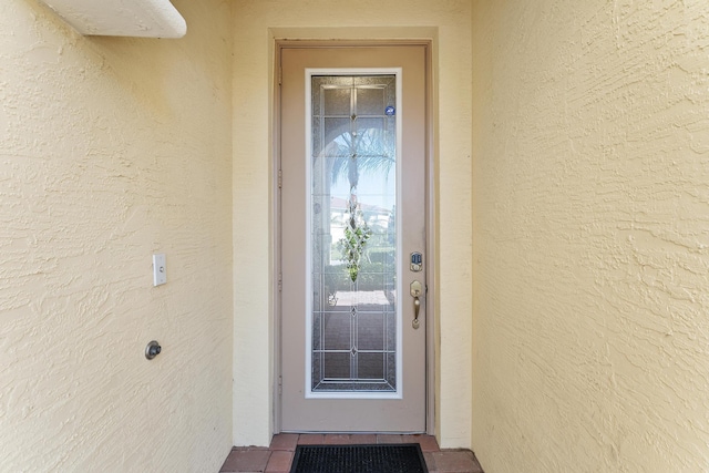 view of exterior entry with stucco siding