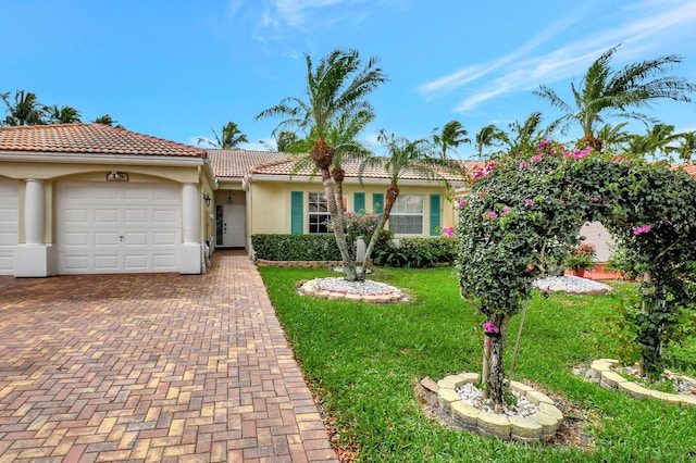 view of front of house with an attached garage, a tiled roof, decorative driveway, stucco siding, and a front yard