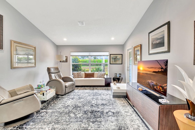 living area featuring recessed lighting, visible vents, and vaulted ceiling