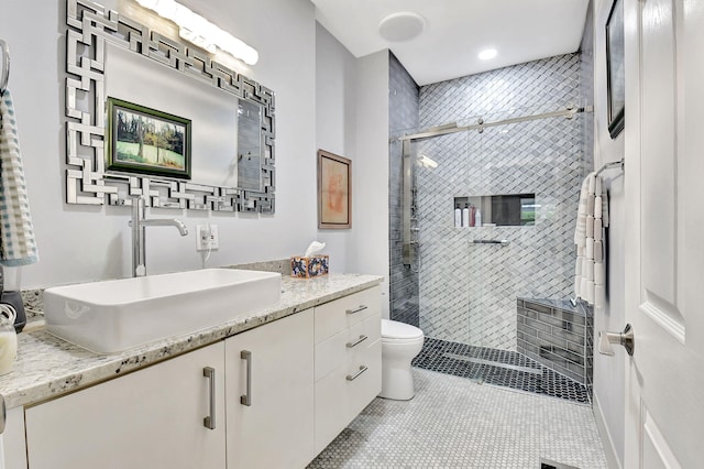 full bathroom with a stall shower, vanity, toilet, and tile patterned floors