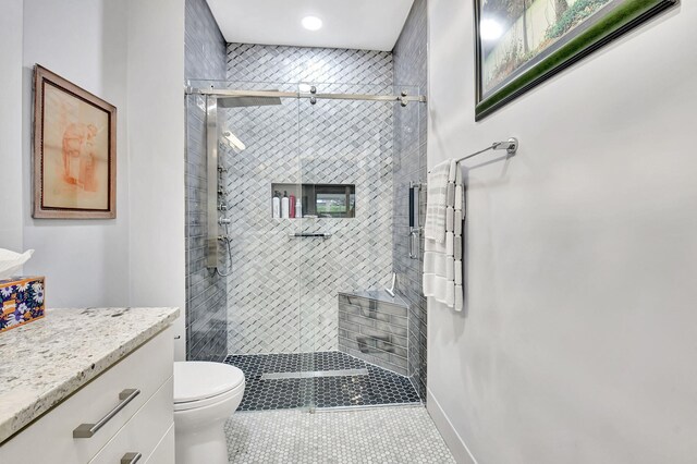 full bath featuring toilet, vanity, baseboards, a shower stall, and tile patterned floors