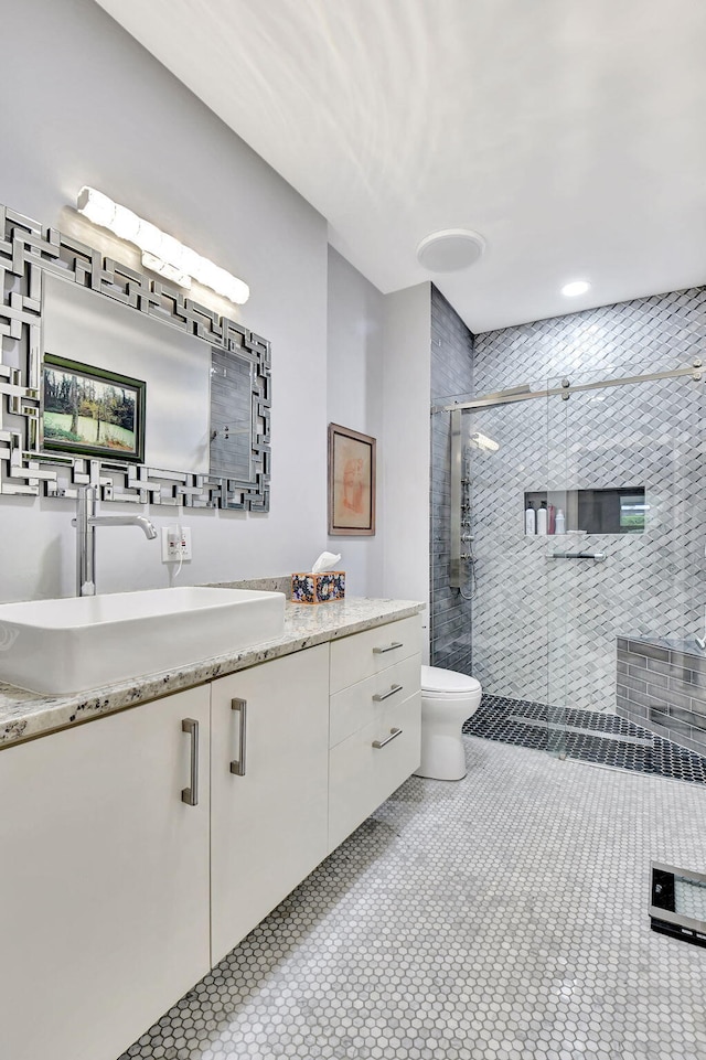 full bathroom featuring vanity, a shower stall, toilet, and tile patterned floors