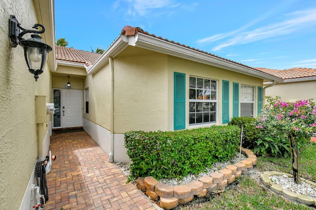 view of home's exterior with a tiled roof and stucco siding