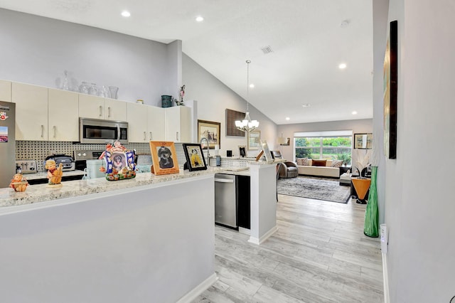 kitchen featuring visible vents, cream cabinets, an inviting chandelier, appliances with stainless steel finishes, and open floor plan