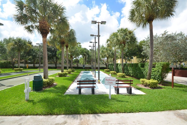 view of community featuring shuffleboard and a yard