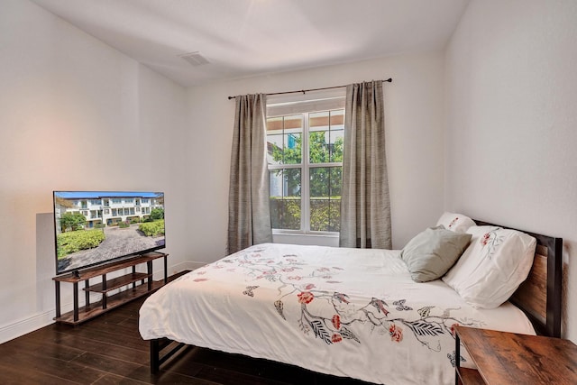 bedroom with dark wood-type flooring, visible vents, and baseboards