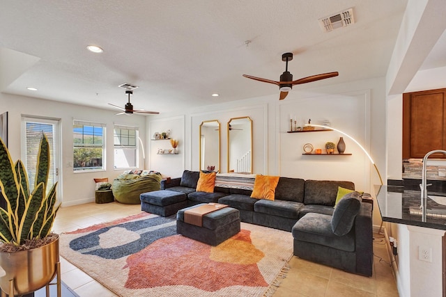 living room featuring light tile patterned floors, ceiling fan, visible vents, and recessed lighting