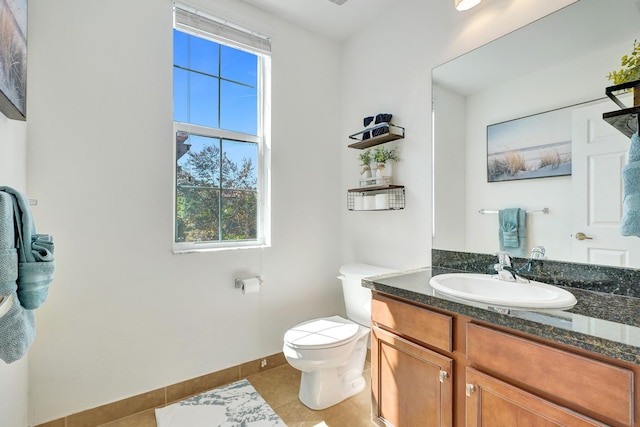 bathroom featuring toilet, vanity, baseboards, and tile patterned floors