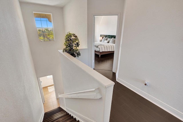 stairway featuring baseboards and wood finished floors